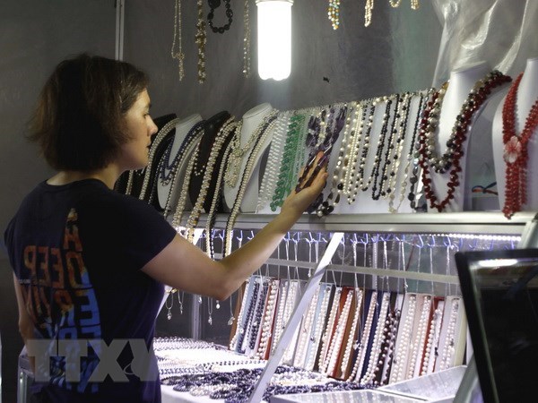 Du khách nước ngoài chọn mua sản phẩm thủ công mỹ nghệ tại chợ đêm Dinh Cậu, đảo Phú Quốc.
